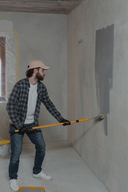 Painter using a roller on an interior wall